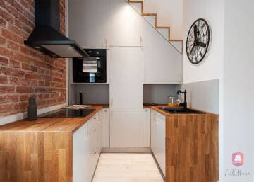 Kompaktowa kuchnia z drewnianymi blatami w mieszkaniu w stylu podróżniczym w Łodzi