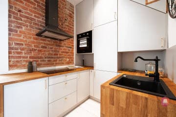 Aneks kuchenny ze ścianą z cegły w mieszkaniu w stylu podróżniczym w Łodzi